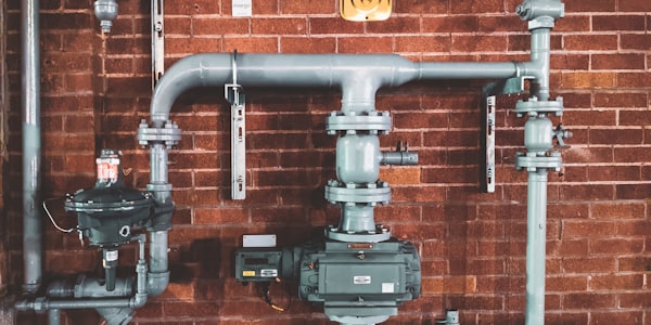 Commercial plumbing pipe system on brick wall
